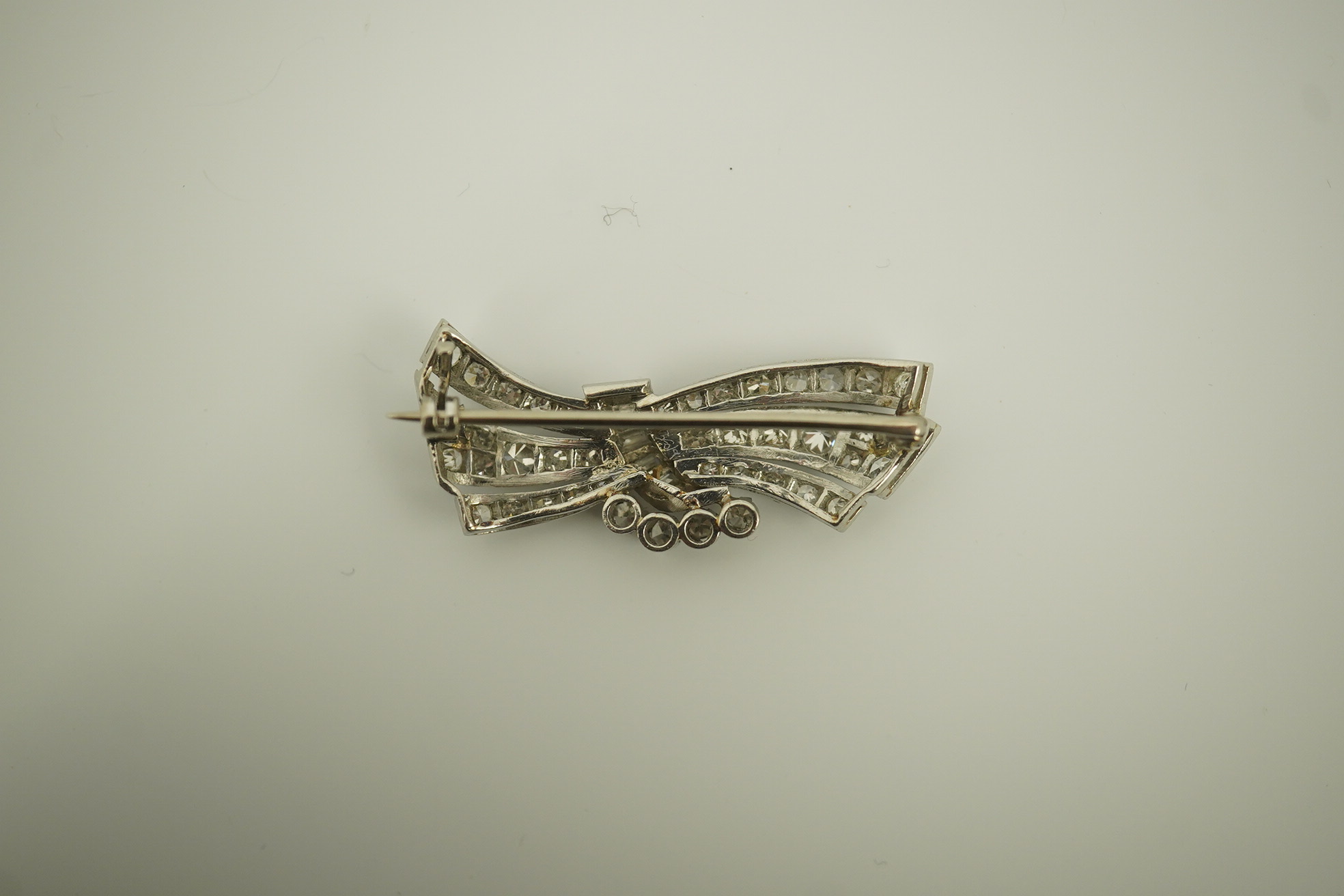 A mid 20th century platinum? and diamond cluster scroll brooch